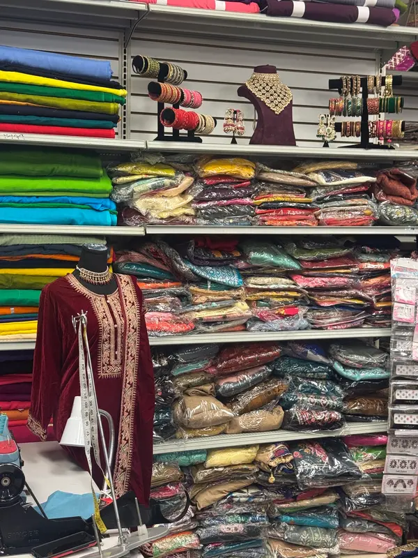 Bolts of fabric and finished pieces on the boutique's racks